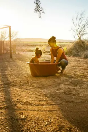  ??  ?? RIGHT Keeping it clean at the camp. Lynelle Govender bathing her toddler at the Wêreldsend Environmen­tal Centre camp.