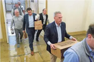  ?? PATRICK SEMANSKY/AP ?? House Speaker Kevin Mccarthy carries food for members of the press covering debt limit negotiatio­ns Saturday on Capitol Hill in Washington. Mccarthy said there was no firm timeline for a final compromise that would raise the nation’s borrowing limit and avoid a catastroph­ic default.