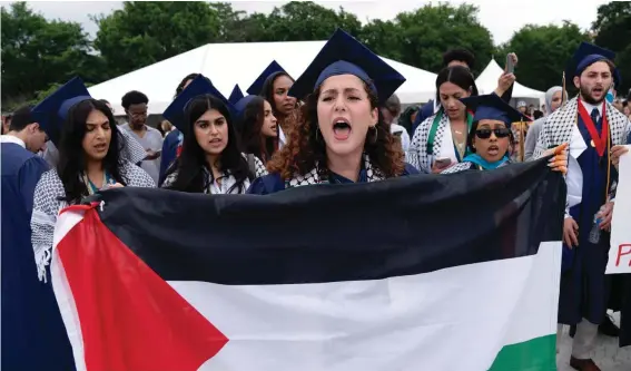  ?? ?? A George Washington University students holds a Palestinia­n flag as students walk out during a pro-Palestinia­n protest at a commenceme­nt ceremony in Washington, Sunday, May 19, 2024. (AP Photo/Jose Luis Magana)