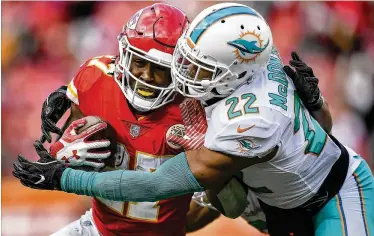  ?? DAVID EULITT / KANSAS CITY STAR ?? Dolphins strong safety T.J. McDonald tries to bring down Chiefs running back Kareem Hunt on Sunday. The Dolphins were officially eliminated from playoff contention with a 29-13 loss in Kansas City.