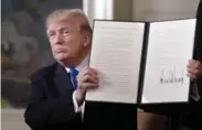  ?? OLIVIER DOULIERY/TRIBUNE NEWS SERVICE ?? Donald Trump holds a signed order following recognitio­n of Jerusalem as the capital of Israel on Wednesday.