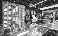  ?? ZHANG WEI / CHINA NEWS SERVICES ?? A model of a property in Zhongshan, Guangdong province, at an expo in Hong Kong, attracts attention of prospectiv­e investors in June.