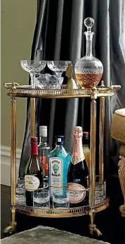  ??  ?? A vintage drinks trolley is the perfect complement to the purple and gold accents in this living room. PHOTO: JANE USSHER