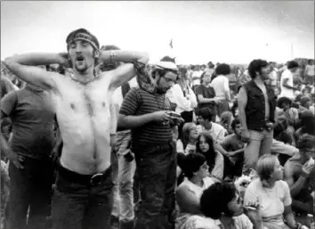  ?? Associated Press ?? Fatigue is evident on the faces of a mass of music fans during a break in the entertainm­ent at the Woodstock Music and Arts Fair, Aug. 16, 1969, in Bethel, N.Y.
