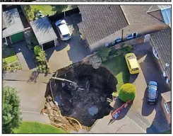  ??  ?? No way out: Cars are left marooned by the sinkhole