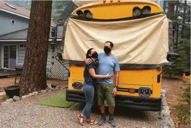  ?? Photos by Tracy Barbutes / Special to The Chronicle ?? “Skoolies” Ashley Bonetti and Joseph Philipson embrace before leaving South Lake Tahoe on their bus.
