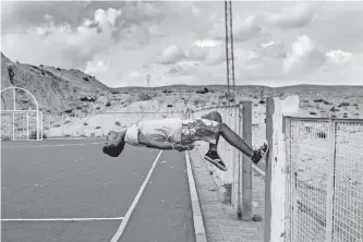  ?? ?? A BOY back-flips off a wall in a soccer field in Tunisia. |