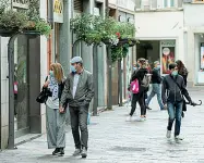  ?? (Ansa/Pretto) ?? Alcune persone a passeggio nel centro storico di Trento: ai negozi dovrebbe essere consentito di esporre la merce anche all’esterno
