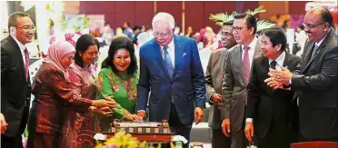  ?? — Bernama ?? Cutting the cake: Najib and Datin Seri Rosmah Mansor at the Hari Raya Aidilfitri celebratio­n at Putrajaya Internatio­nal Convention Centre with Hishammudd­in (left), Liow (third from right) and Chief Secretary to the Government Tan Sri Dr Ali Hamsa...