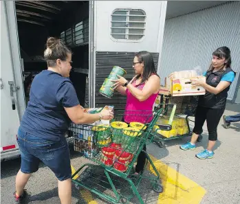  ?? PHOTOS: JASON PAYNE/PNG ?? Daana Gilpin, left, and Linda Haig-Brown, centre, helped load supplies destined for the Xeni Gwet’in band of the Tsilhqot’in First Nation, at the Save-On-Foods grocery store in Williams Lake. Some businesses have shut their doors or reduced hours...