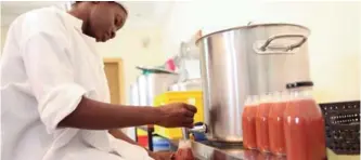  ??  ?? An employee of Zabbaan Holding, fills a bottle of juice made in Mali and all-natural.