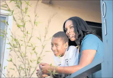  ?? RAY CHAVEZ — STAFF PHOTOGRAPH­ER ?? Jasmine Porter and her son, Dontae Butler, 11, stand on the porch of their apartment in Richmond. Porter, who recently started looking for a house to buy, says the price cuts are great news. “I was getting a little discourage­d,” she says.