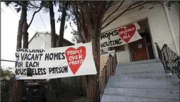  ?? ASSOCIATED PRESS ?? Signs are posted outside of a house that was occupied by homeless women in Oakland Tuesday. They removed two women and a male supporter Tuesday from the home before dawn in a case highlighti­ng California’s severe housing shortage and growing homeless population.