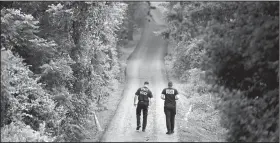  ?? AP/MATT ROURKE ?? Pennsylvan­ia State Police officers walk up a driveway Friday in Solebury, Pa., as the investigat­ion of four missing young Pennsylvan­ia men continues.