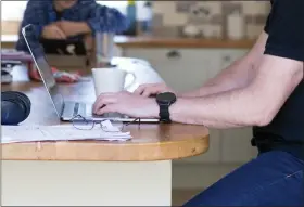  ?? CHRIS RATCLIFFE — BLOOMBERG ?? A worker works on his laptop in his kitchen whilst working from home in Danbury, U.K., April 7, 2020.