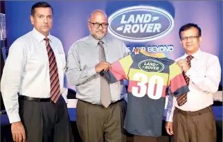  ??  ?? Sheran Fernando, Managing Director SML Frontier Automotive (Pvt) Ltd (centre), handing over the Trinity College rugby jersey for 2014 to Trinity College Brigadier Udaya Aryaratne at a media conference last week. Also in the photo is Jayantissa...