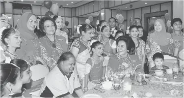  ??  ?? Rosmah (seated second right) shares a light moment with orphans and children with disablity at a Deepavali tea gathering organised by Bakti. — Bernama photo