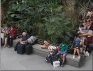  ?? (AP/Paul White) ?? Passengers wait in the botanical garden inside the Atocha rail station Saturday in Madrid.