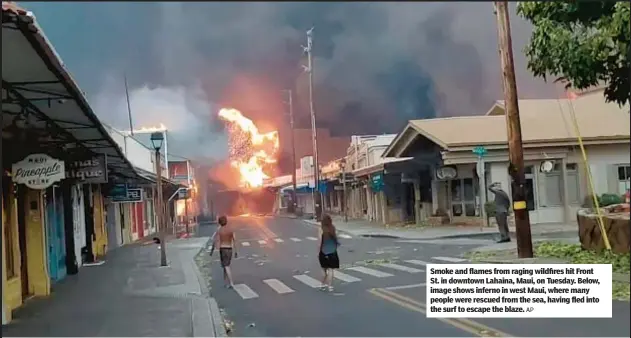  ?? AP ?? Smoke and flames from raging wildfires hit Front St. in downtown Lahaina, Maui, on Tuesday. Below, image shows inferno in west Maui, where many people were rescued from the sea, having fled into the surf to escape the blaze.
