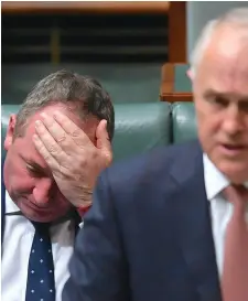  ??  ?? Barnaby Joyce reacts behind Australian Prime Minister Malcolm Turnbull in the House of Representa­tives
