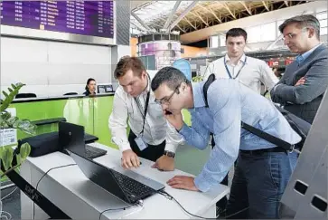  ?? Sergei Chuzavkov Associated Press ?? EMPLOYEES USE a laptop at Boryspil Internatio­nal Airport, Ukraine’s largest, after a virus infected its computer system, delaying some flights. An official said the attack was an attempt to destabiliz­e the country.