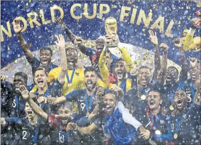  ?? PHOTOS BY MATTHIAS SCHRADER — THE ASSOCIATED PRESS ?? France goalkeeper Hugo Lloris hoists the World Cup championsh­ip trophy while surrounded by teammates after they defeated Croatia, 4-2.
