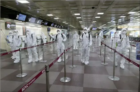  ?? KIM JOO-SUNG — YONHAP VIA AP ?? South Korean army soldiers wearing protective suits spray disinfecta­nt to prevent the spread of the new coronaviru­s March 6 at Daegu Internatio­nal Airport in Daegu, South Korea.