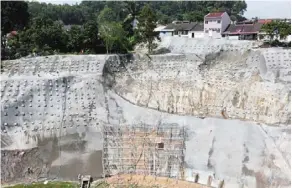  ?? — IZZRAFIQ alias/the Star ?? Constant monitoring: (top) the malaysian Institute of Public Works personnel helping to rehabilita­te landslides at taman bukit Permai 2 and taman mega Jaya in ampang, including (above) shoring the areas with concrete.