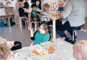  ?? MATHIAS SVOLD/THE NEW YORK TIMES 2019 ?? Some rich countries contribute far more per year for a toddler’s care than the United States, which spends just 0.2% of its GDP for those 2 and younger . Above, children eat lunch at a public child care center in Copenhagen, Denmark.