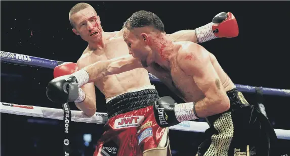  ??  ?? Glenn Foot lands a blow on Robbie Davies Jnr in their British and Commonweal­th Super-Lightweigh­t Championsh­ip fight. Pictures by Simon Stacpoole.