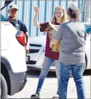  ?? Westside Eagle Observer/MIKE ECKELS ?? Bethany Porter (center) hands a box of canned goods to Caroline Krueger (right) during the Saturday morning Pathway to Progress food drive held at the city hall annex building (old Head Start building) in Decatur.