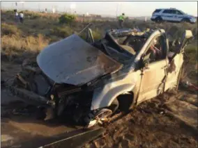  ?? BARRY WHITE — KTNV VIA THE AP ?? The wreckage of a van that collided with a Dallas Cowboys bus is seen near Kingman, Ariz., Sunday. Authoritie­s said multiple people in the van died but nobody on the bus was seriously injured.