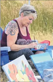  ??  ?? Barrington artist Anne Lovitt works on a piece during Cape Day 2018.