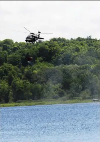  ?? ERICA MILLER — THE SARATOGIAN ?? State police and the New York Army National Guard teamed up Wednesday to conduct fifire bucket training. The exercises took place in preparatio­n for wildfifire season. The state police used 750-pound versions of fifire buckets to fifill water up,...