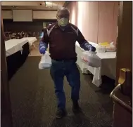  ?? JORDANA JOY — THE MORNING JOURNAL ?? German’s Villa owner Cliff German brings out a meal for delivery at the banquet hall in Vermilion. The business has been serving meals to first responders and other essential workers in addition to its carryout service.