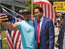  ?? Marcio Jose Sanchez / Associated Press ?? Larry Elder (right), the front-runner to replace Gov. Gavin Newsom if he loses the recall vote, poses for selfies in July.