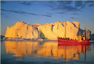  ??  ?? Colourful: Greenland’s icebergs glow in this land of the Midnight Sun. Above: Homes are painted in rainbow hues