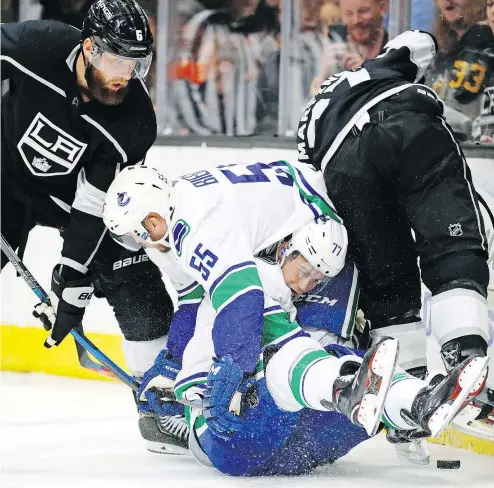  ?? — THE ASSOCIATED PRESS ?? Vancouver Canucks defenceman Alex Biega and forward Nikolay Goldobin collide as Los Angeles Kings defenceman Jake Muzzin, left, looks on Monday during the Kings’ 4-1 pre-season victory in Salt Lake City.