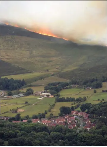  ?? AFP ?? Hot at the top: The moorland wildfire burning on the hills above Dove Stone Reservoir near Stalybridg­e, northwest England.—