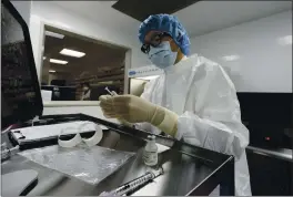  ?? PHOTOS BY MARK LENNIHAN — THE ASSOCIATED PRESS ?? A pharmacist labels syringes in a clean room where doses of COVID-19 vaccines will be handled at Mount Sinai Queens hospital in New York on Wednesday.