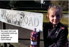  ??  ?? Six-year-old Lola Lancaster puts up a dog poo dispenser on Carrs Road