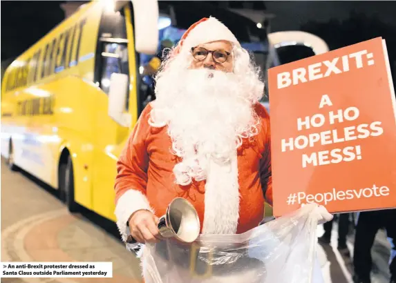  ??  ?? &gt; An anti-Brexit protester dressed as Santa Claus outside Parliament yesterday