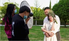  ?? — reuters ?? For better or for worse: peng and yao posing for their wedding photograph­y shoot in Wuhan.