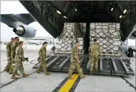  ?? AP PHOTO/MICHAEL CONROY ?? Crew members of a C-17 begin to unload a plane load of baby formula at the Indianapol­is Internatio­nal Airport in Indianapol­is on Sunday.