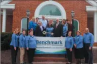  ?? SUBMITTED PHOTO ?? Benchmark Federal Credit Union’s outgoing President & CEO David LaSala, left, passes the key to his successor Daniel J. Machon Jr. right. Both are flanked by board members and staff at Benchmark’s headquarte­rs in West Chester.