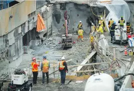  ?? ASHLEY FRASER ?? June 11 Pedestrian­s get a peek at the status of the sinkhole on Day 4, as crews continue their work.