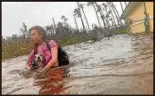  ??  ?? Ein KYdchen aus Freeport auf Grand Bahama watet mit ihrem Hund durch die Wassermass­en.