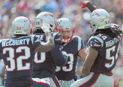  ?? STAFF PHOTO BY MATT STONE ?? SQUISH THE FISH: Devin McCourty (32), Malcom Brown (90) and Dont’a Hightower (54) celebrate a fumble recovery by Kyle Van Noy (53) during the Patriots’ 38-7 rout of the Dolphins yesterday.