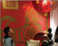  ?? CHANG JUN / CHINA DAILY ?? A boy checks ornaments featuring Chinese New Year images at a Macy’s store in San Francisco on Jan 22. On display are some of the limited-edition designer brands produced for the Year of the Dog,