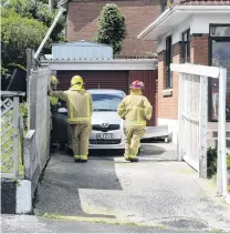  ??  ?? Roof gone . . . Firefighte­rs in Gloucester St, Andersons Bay, Dunedin, after high winds blew the roof off this car port.